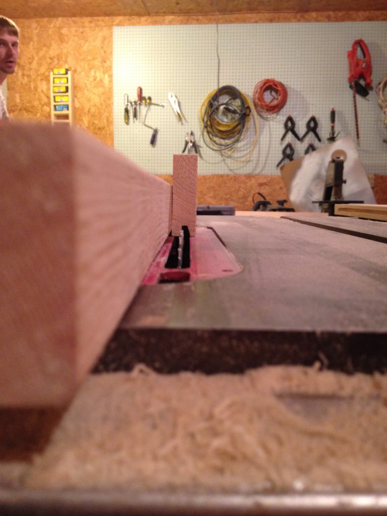 Rip fence on table saw set to ¼ inch from the blade to cut dadoes into cabinet door frame