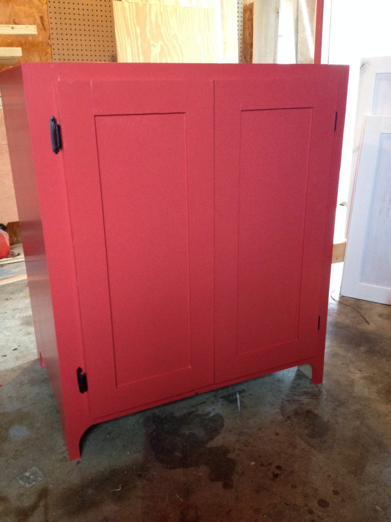 Small red cabinet with shaker cabinet doors