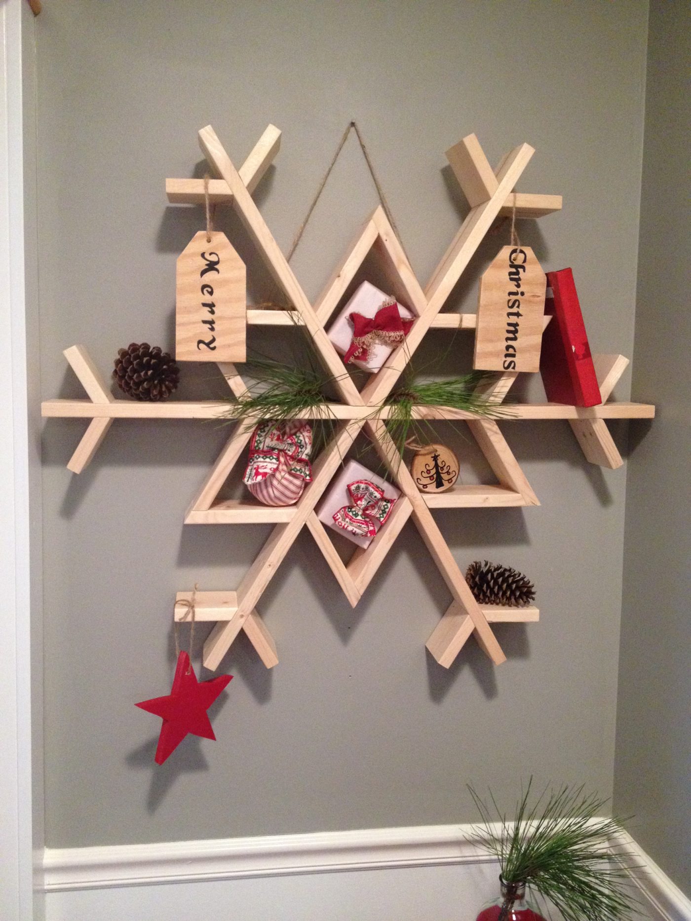 Wooden snowflake shelf decorated and hanging on wall