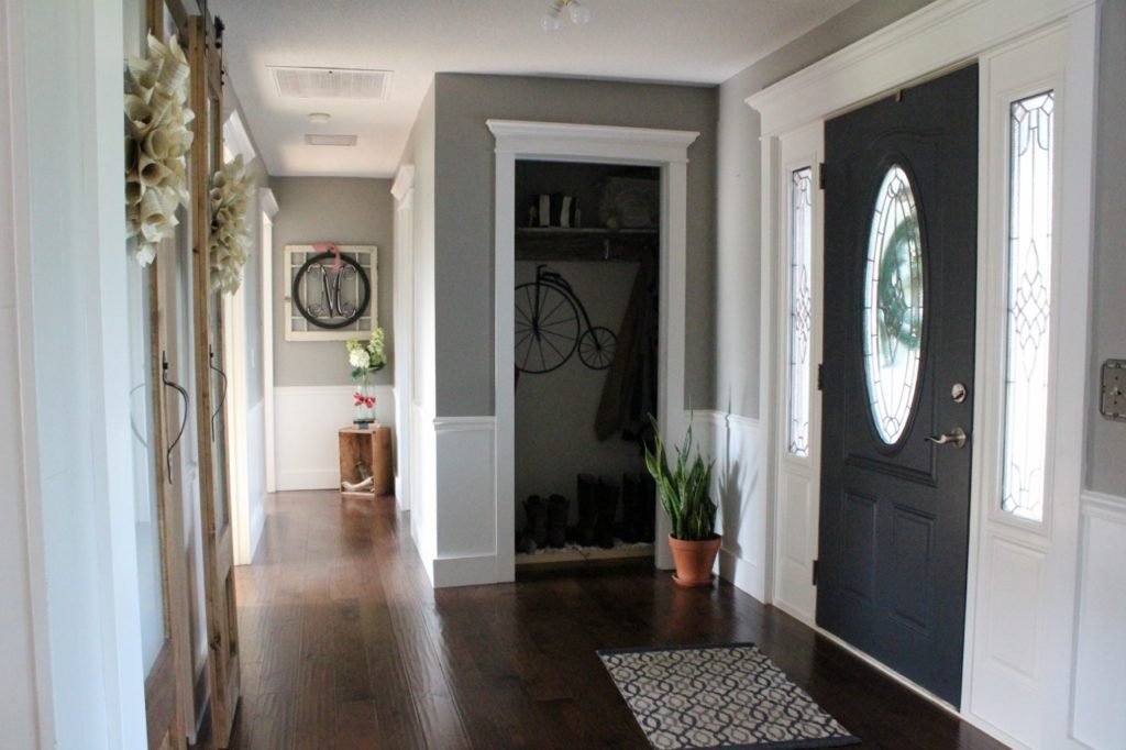 Light and bright foyer--grey walls, white trim, navy door, sliding doors