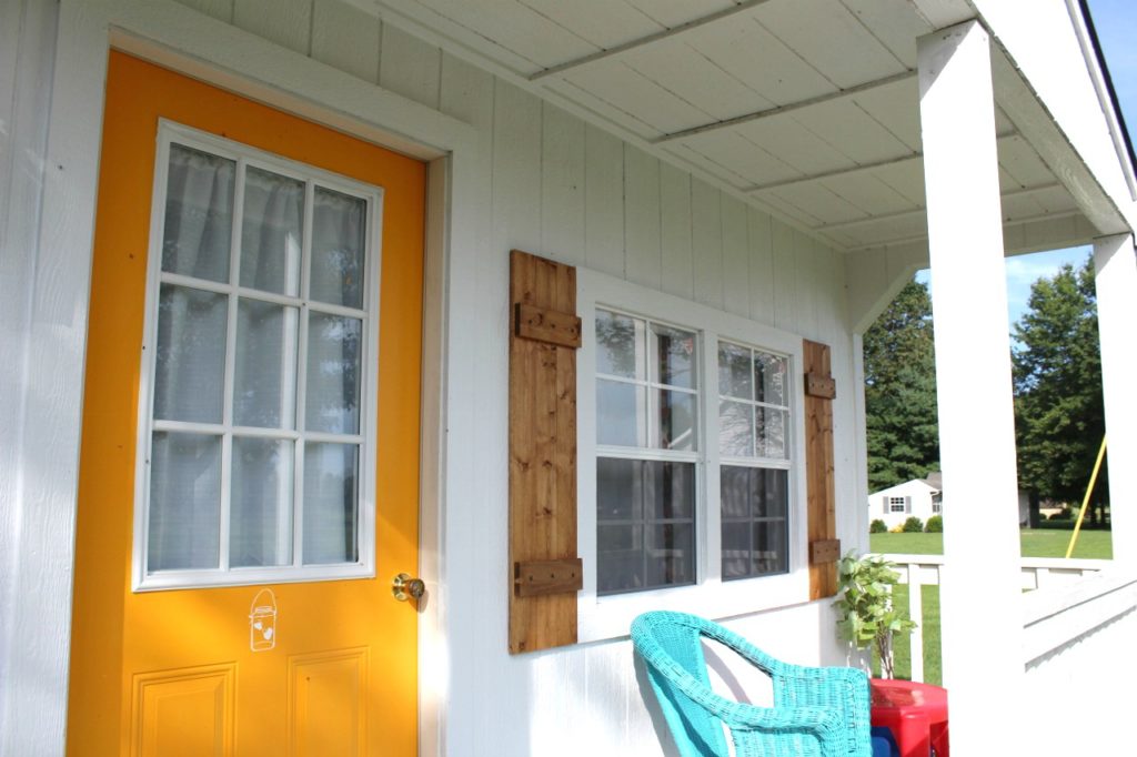 Shutters hung on each side of she shed front window