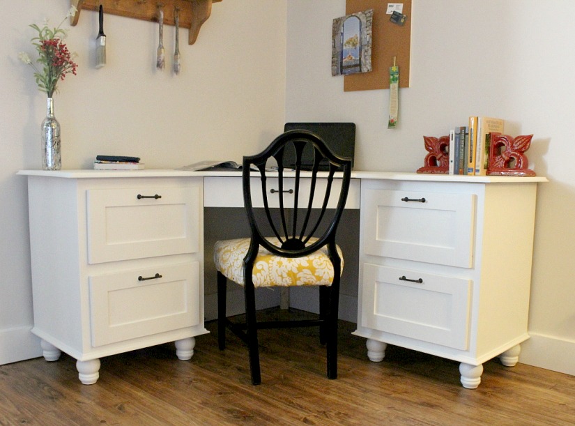Finished DIY corner desk painted white in corner of office space with black chair 