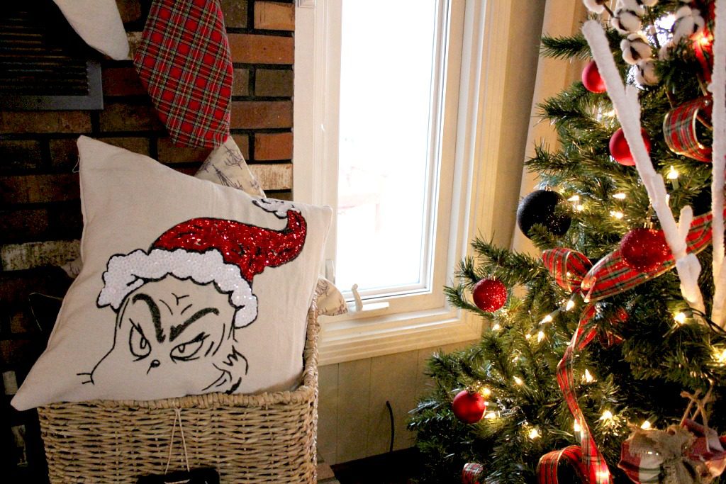 Grinch Pillow cover in basket next to Christmas tree
