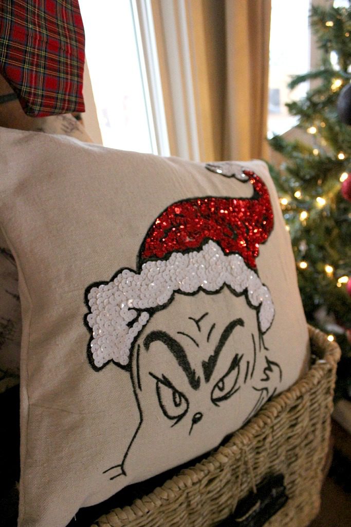 Close up of DIY Grinch Pillow Cover in basket by Christmas Tree