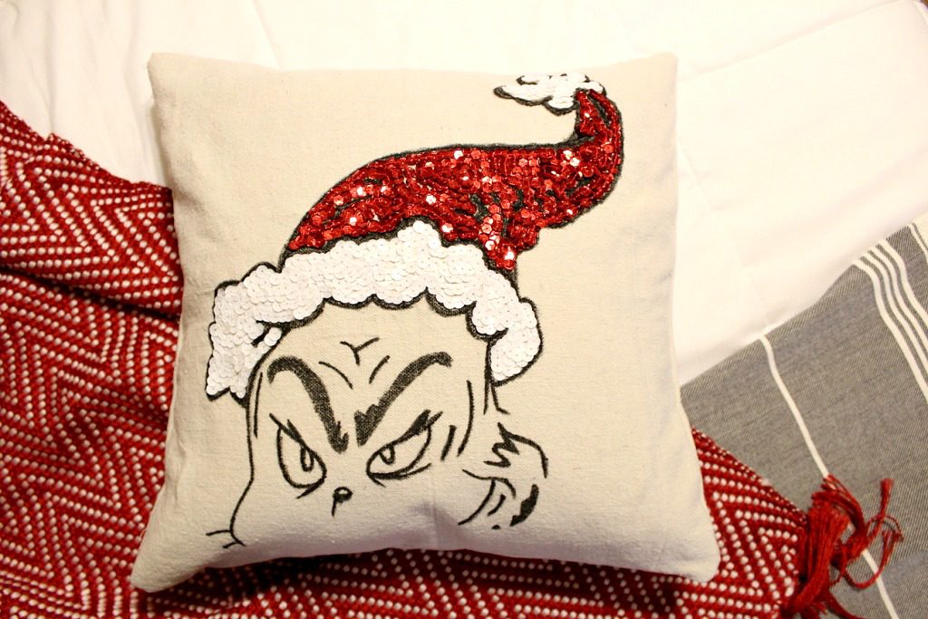 DIY Grinch pillow cover with pillow inserted laying on blanket