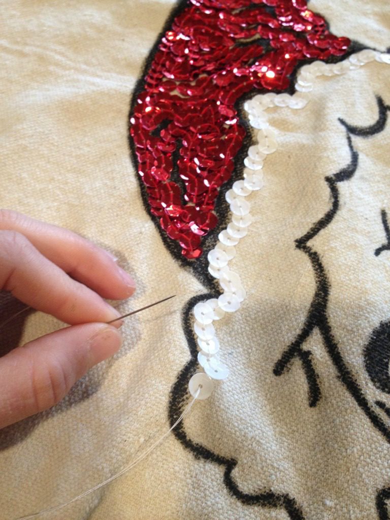 Close of of stitching sequins onto pillow cover