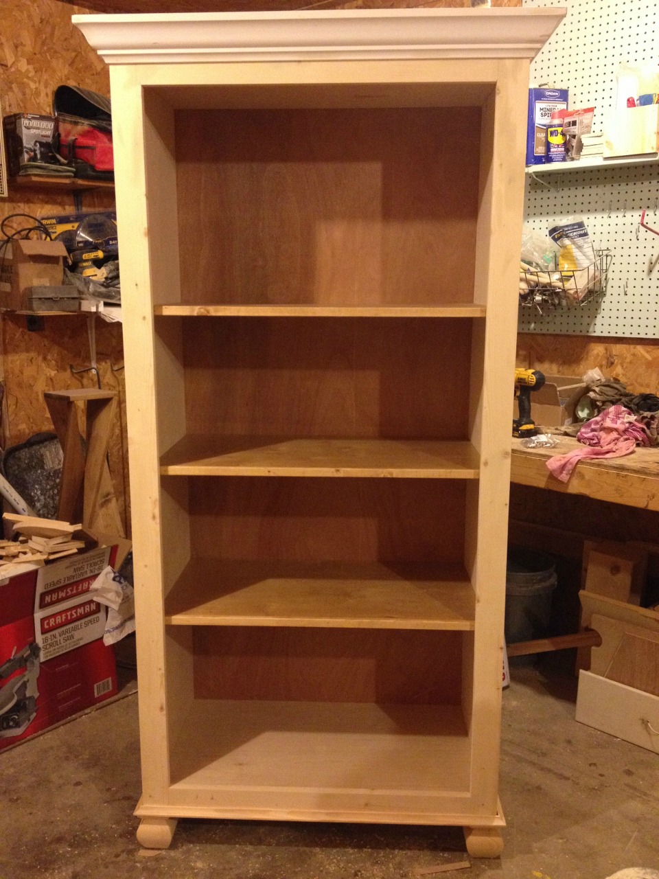 Unfinished stand alone tall bookshelf in workshop