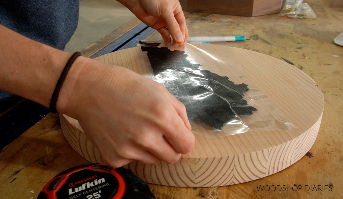 Applying Cricut vinyl stencil to wood circle as staining template