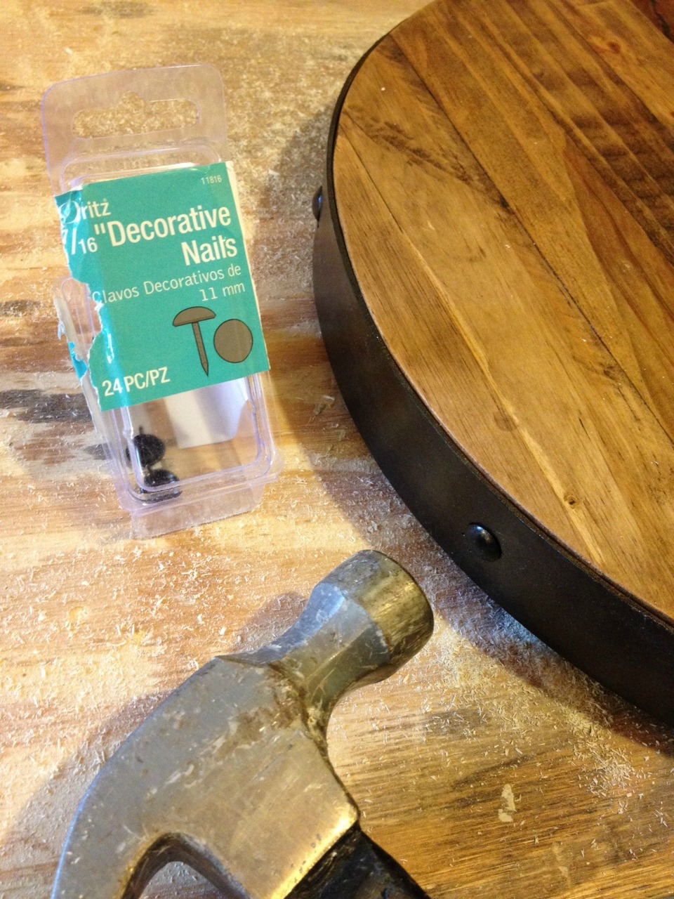 Adding decorative nails to fake metal band on wooden lazy susan