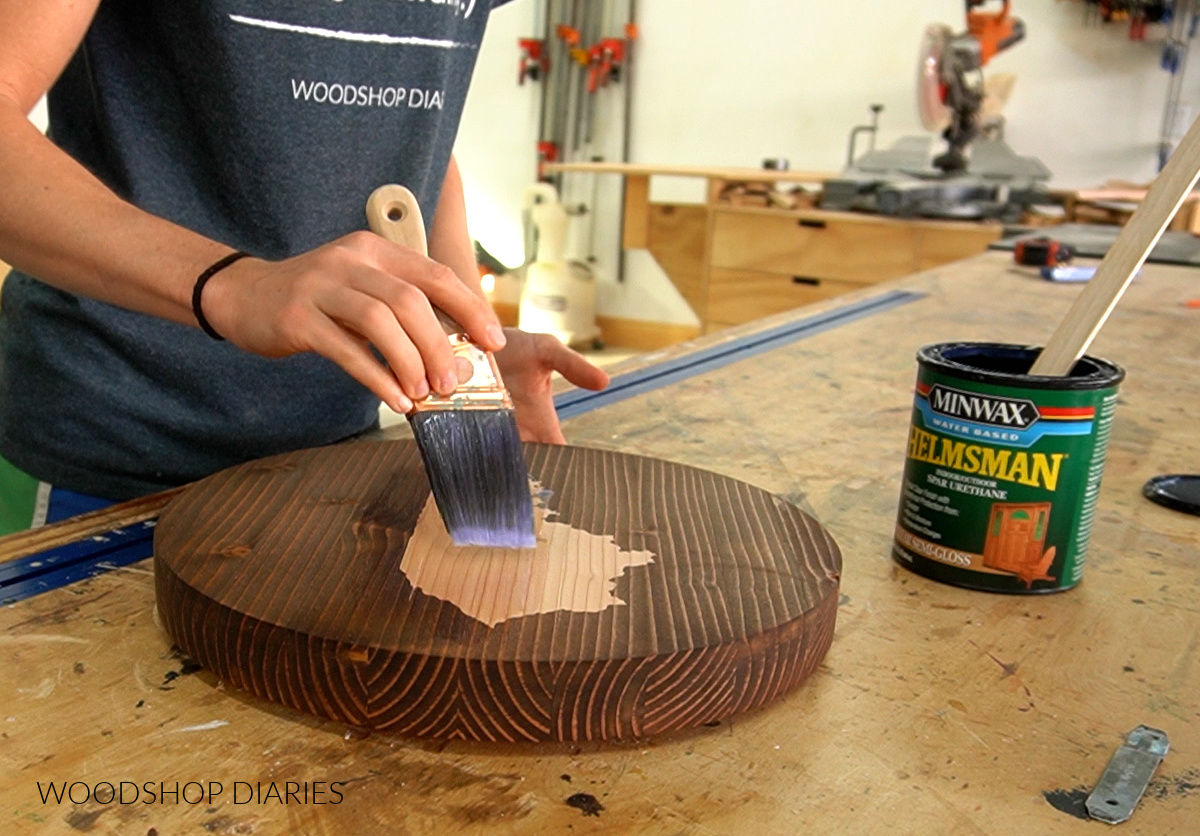 Shara Woodshop Diaries applying a clear finish--Minwax Helmsman--to a round wood serving plate