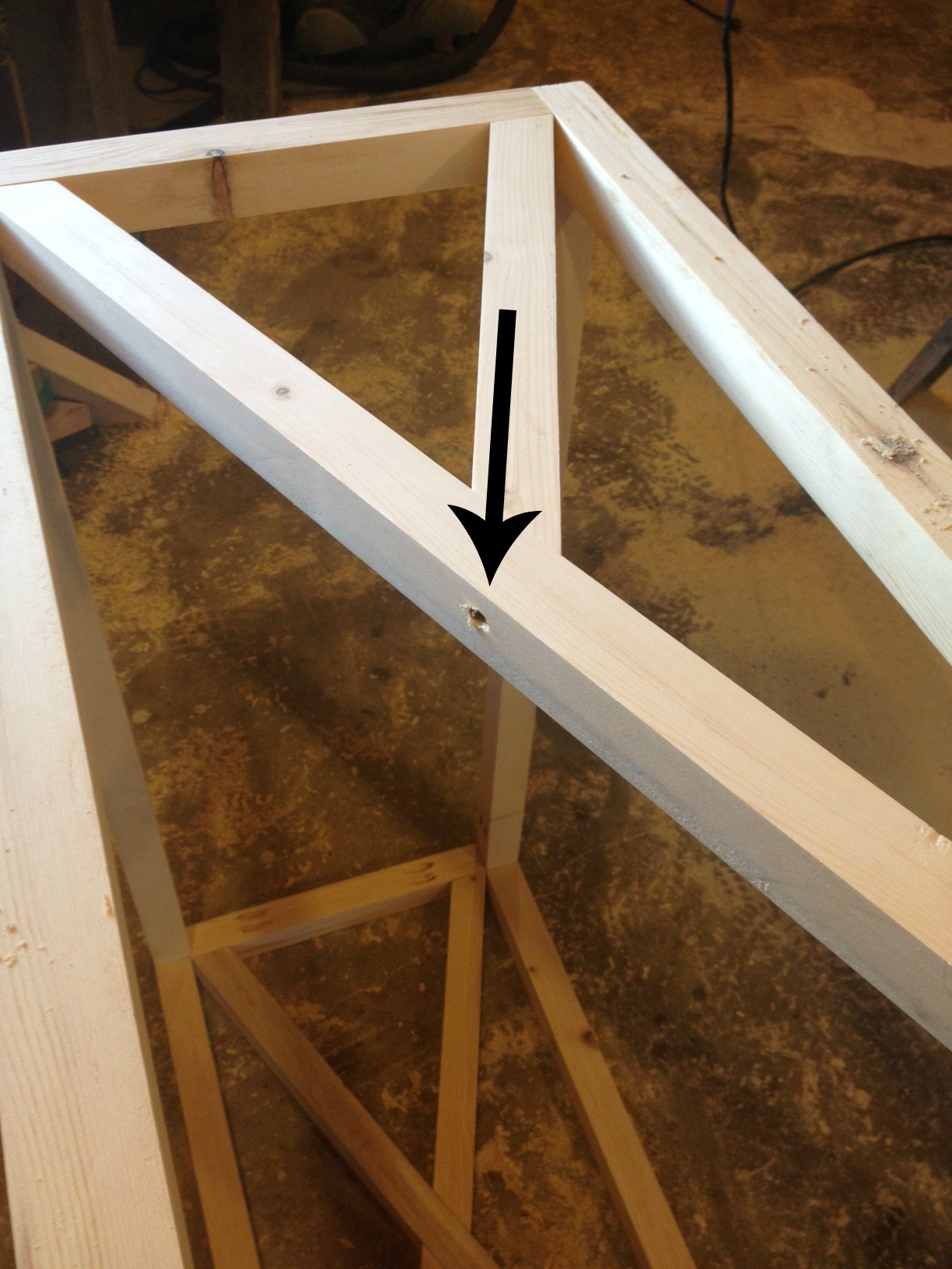 Up close showing where to put screw to attach X frame in console table