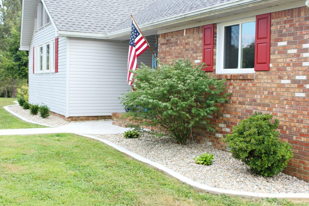 Indiana river rock and concrete edging update this home's worn out landscape