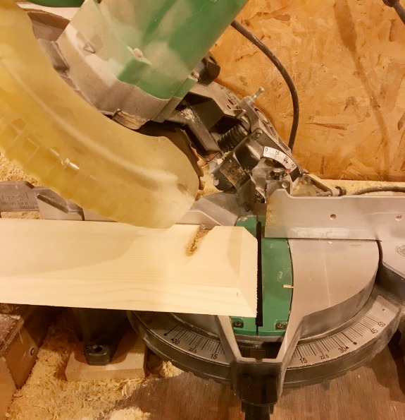 Use miter saw to miter ends of floating shelf box boards to 45 degrees