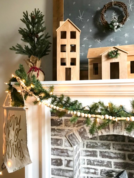 Fireplace with DIY wooden Christmas village sitting on mantle