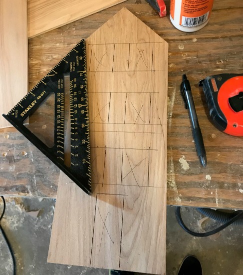 window and door shapes drawn on wood to be cut out for DIY wooden Christmas village house