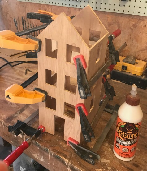 DIY Scandinavian Christmas village house glued and clamped together to dry.