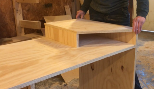 Placing plywood cubby top panels onto miter saw station