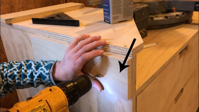 Close up installing spacer blocks to side panels of miter saw stand