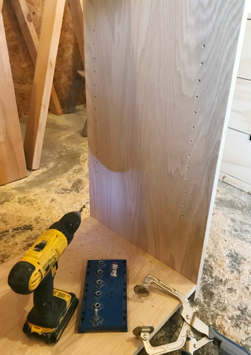 shelf pin holes drilled into side panels of diy bookshelf cabinet