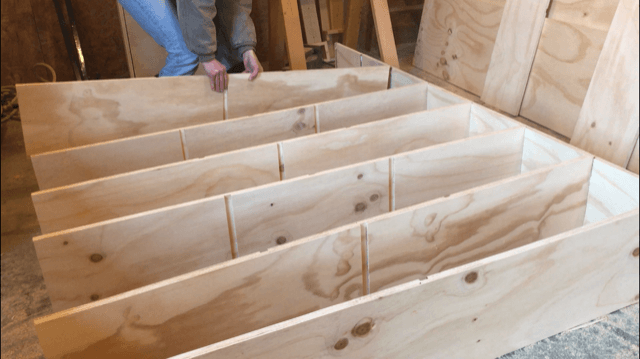 Placing shelves into dadoes to assemble modern DIY boookshelf