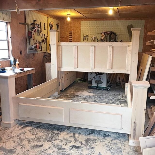 Unfinished DIY storage bed in small woodworking shop