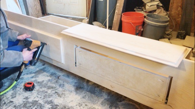 Installing drawer fronts onto drawer boxes in foot board