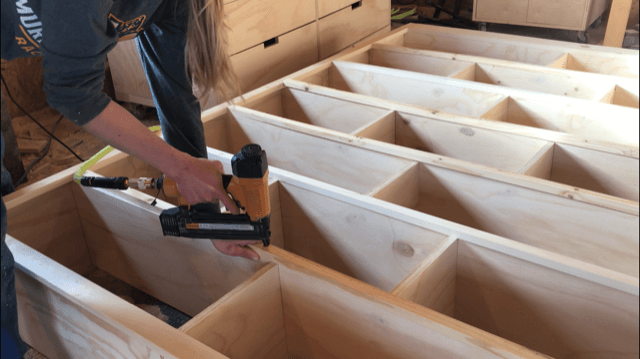 Nail front edge trim onto DIY modern stand alone bookshelf