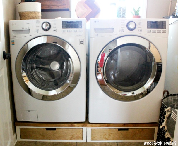 Washer and dryer on wooden pedestal stands with drawers