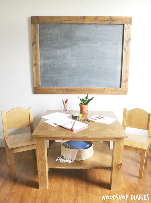 DIY childrens table and two chairs in front of chalkboard