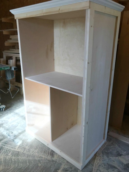 Plywood storage cabinet trimmed out with middle shelves added inside