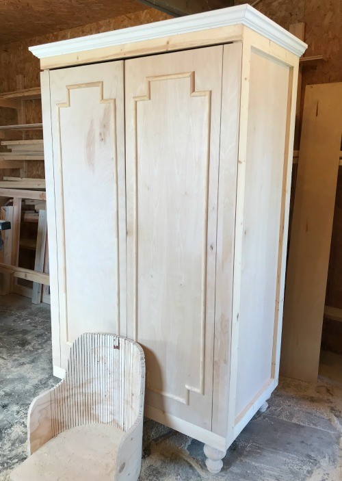 Plywood cabinet door with decorative trim installed test fit over armoire cabinet