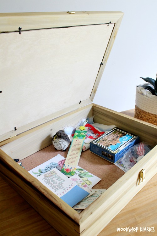 Lid of picture frame box open showing trinkets inside