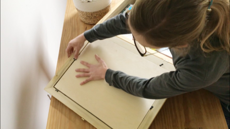 Shara placing picture frame backer onto box lid