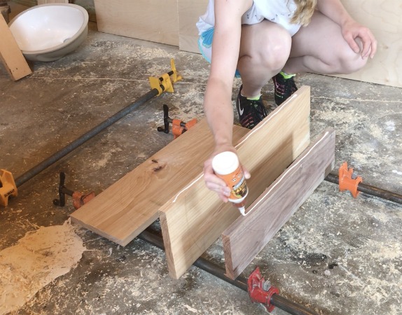 applying glue to walnut and hickory boards to make clock panel