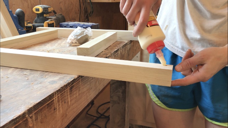 Apply wood glue into dowel holes to glue up nightstand frame