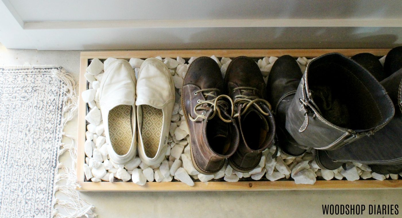 Simple wooden boot tray with white decorative rocks--overhead view with shoes and boots placed in tray