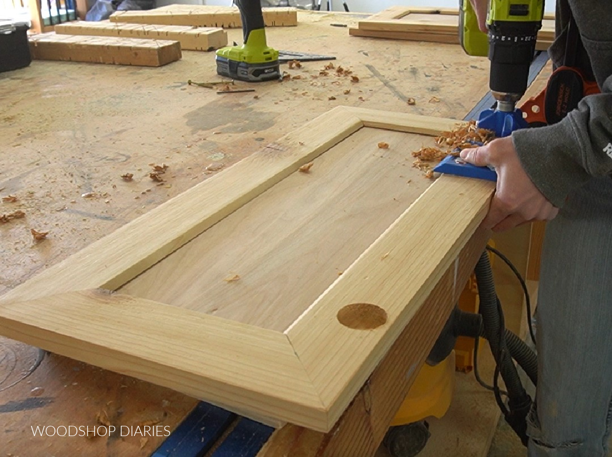 One hole drilled and one being drilled out to install hinge cups on cabinet door