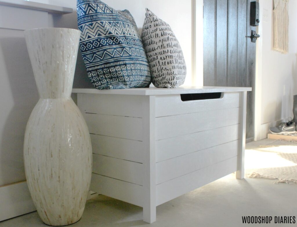 DIY Faux slat toy box painted white used as an entryway bench