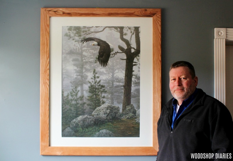 Dad next to his custom DIY picture frame with eagle print in his blue office