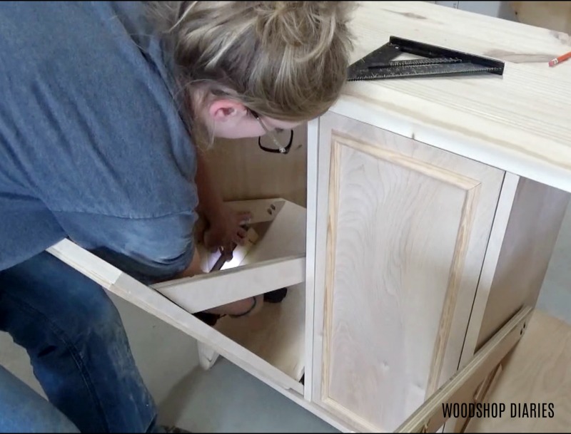 screw positive stop block into DIY laundry hamper storage cabinet