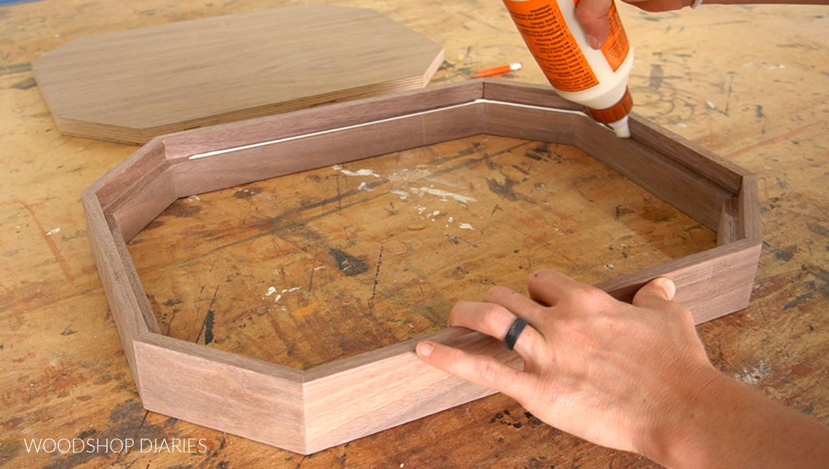 applying wood glue along tray bottom edge
