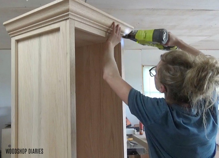 Shara Woodshop Diaries nailing crown molding around top of linen cabinet DIY project