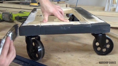 Applying black paint to wagon frame