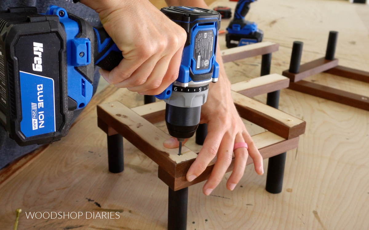 Close up of Shara Woodshop Diaries predrilling pilot hole for accordion rack assembly