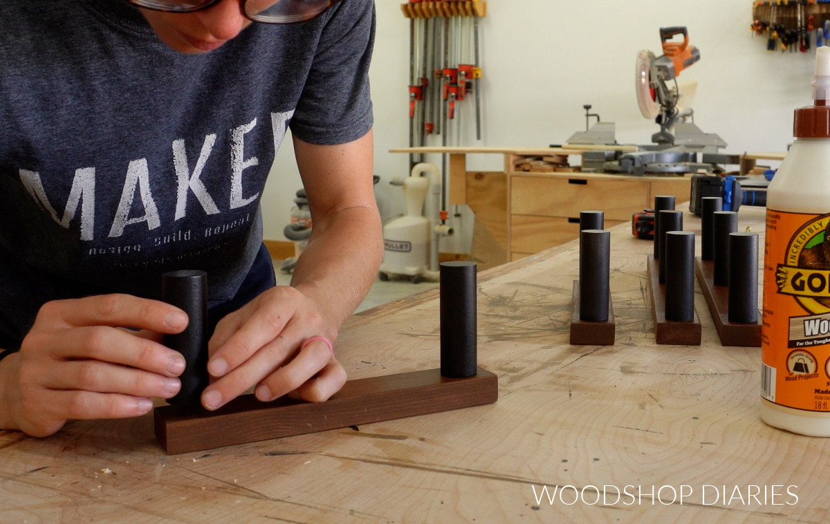 Shara Woodshop Diaries gluing dowel pegs to 1x2 boards on workbench