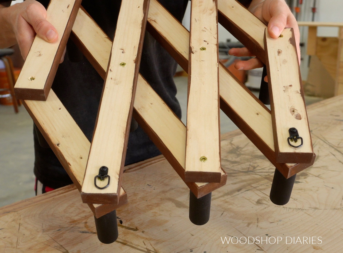 Close up of D hangers installed on back of accordion hat rack