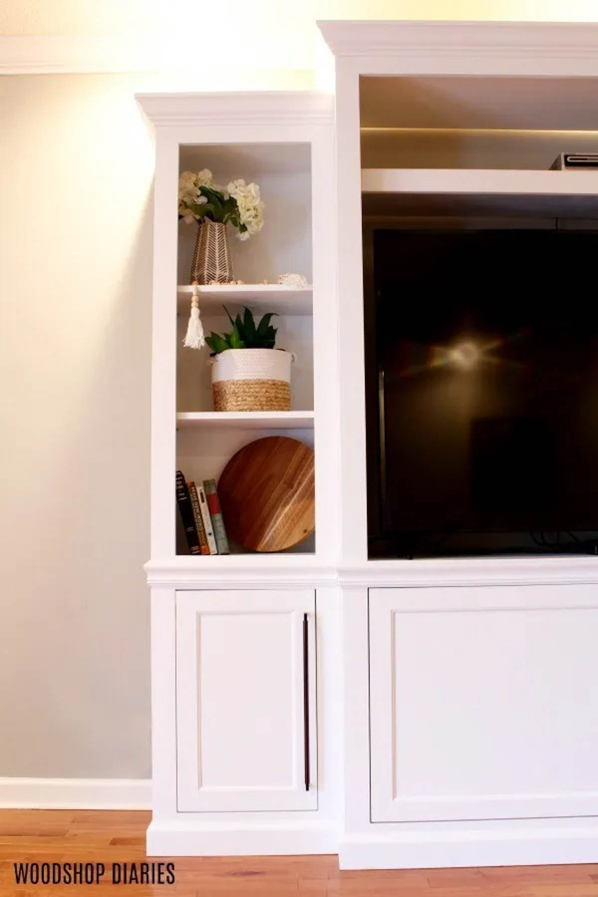 Left side of DIY entertainment center with cabinets and shelves