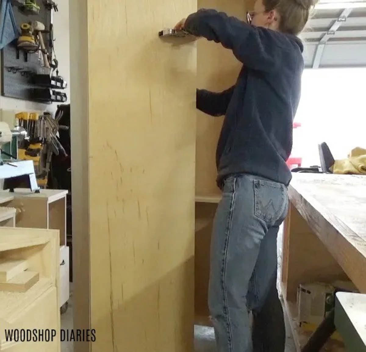 Staple backing onto side cabinet carcasses of DIY Entertainment center