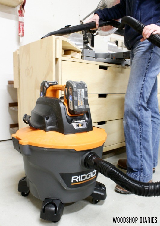 Ridgid 18V Shop Vacuum cleaning sawdust off miter saw stand