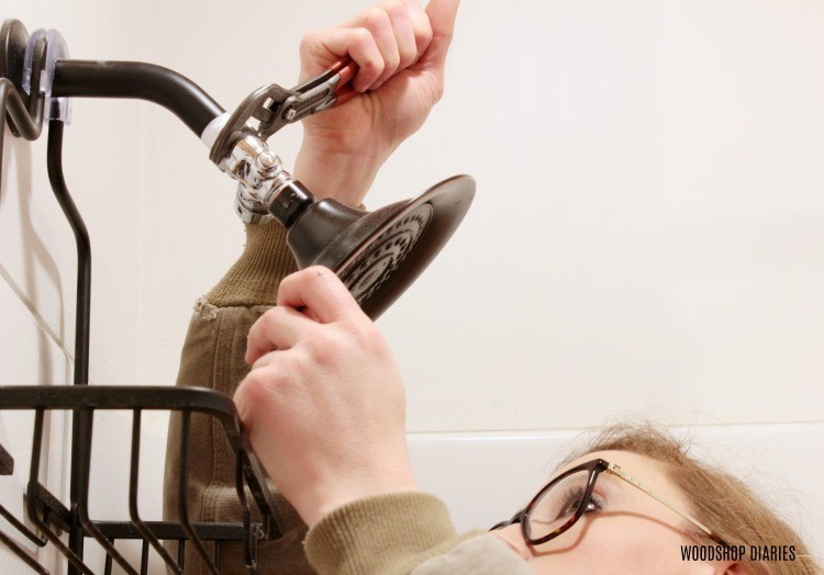 Using pliers to tighten shower fixture to fix leak--homeowner gift ideas for routine maintenance